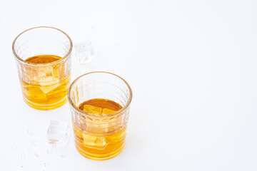 Glass of strong alcoholic drink whiskey with ice. Alcohol background