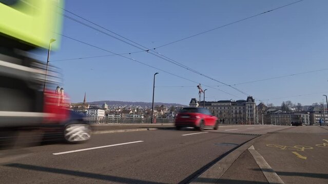 Traffic over Quay Bridge at City of Z&uuml;rich with tram crossing on a sunny winter day. Movie shot February 9th, 2023, Zurich, Switzerland.