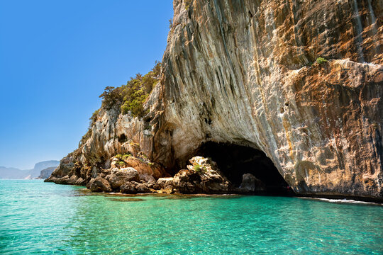 Cliffs and turquoise waters near Grotta del Bue Marino seen from the sea, Sardinia, Italy