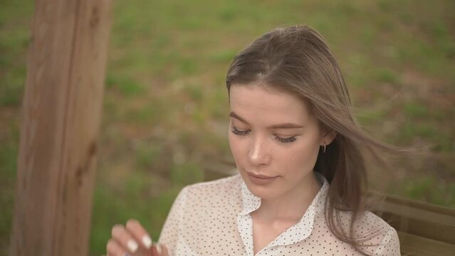 a girl in the park on a bench cries and wipes her tears with a handkerchief. slow motion video. High quality FullHD footage