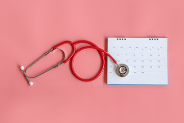 Calendar, stethoscope, on a pink background, health care concept.