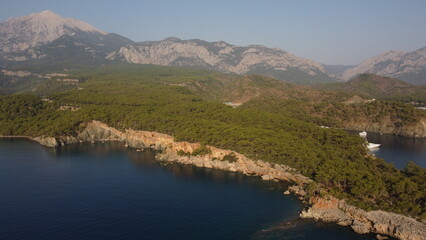 A bay Cennet Koyu with a Tahtalı Dagi mountain view from a drone. 