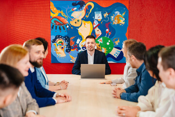 The male manager holds a meeting for subordinates in the meeting room.