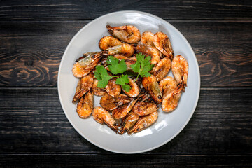fried shrimp with soy sauce, garlic in gray plate on wooden table Seafood Traditional thai food