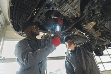 mechanics replacing clutch using various tools, car workshop medium shot. High quality photo