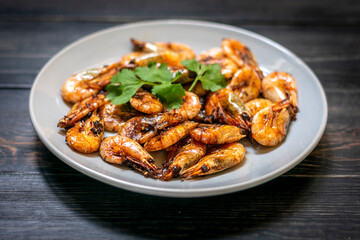 fried shrimp with soy sauce, garlic in gray plate on wooden table Seafood Traditional thai food
