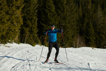 Nordic skiing or Cross-country skiing classic technique practiced by man in a beautiful panoramic trail at morning.Selective focus.