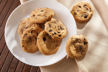 chocolate chip cookies close-up. pastries on a white plate with a napkin. dessert under the bright sun. bakery on a light background. High quality photo