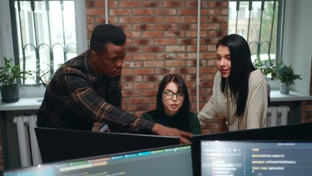 diverse multiethnic coworkers in office of IT-company, man and women discussing project of website
