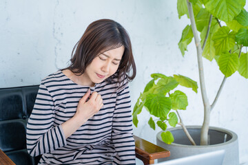 リビングで動悸に苦しむ女性