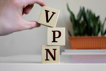 Hand holding wood cube block with 'VPN' text. VPN - short for Virtual Private Network