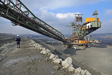 Bucket-wheel excavator during excavation at the surface mine. Huge excavator on open pit mine.