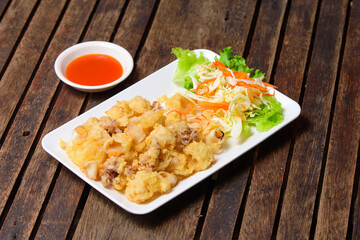 Fried crispy squid in the white dish.