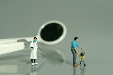 Miniature people toy figure photography. Refusing go to dentist women checking teeth concept. A father and son standing in front of dentist tool equipment