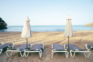 Scenic view to a chaise lounges and umbrellas on the sandy beach