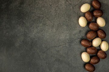 Composition with chocolate Easter eggs on dark background copy space top view. Happy Easter holiday concept