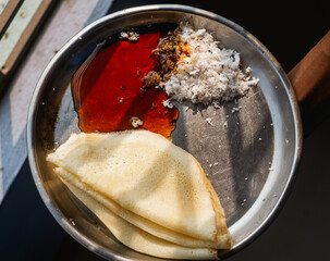 Close up of popular indian food called dosa or dosha with coconut and date juice made mithe
