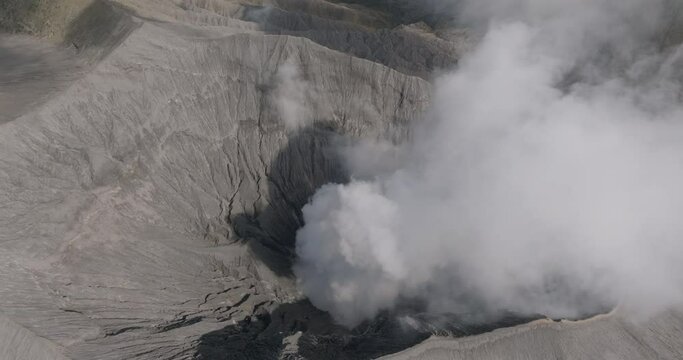 Aerial Panning Shot Of Smoke Emitting From Famous Bromo Mountain On Sunny Day - Java, Indonesia