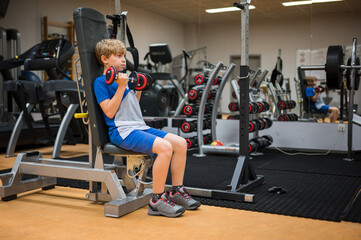 Fototapeta na wymiar Young boy exercises in the professional gym