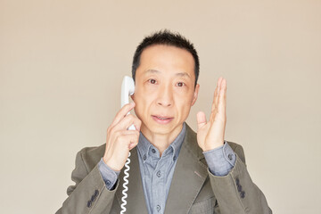 電話でアドバイスをしている中年サラリーマンの様子