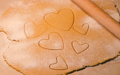 Valentine's day heart shaped cookie from ginger raw dough with flour and rolling pin