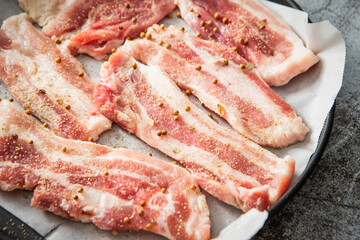 Whole pepper and raw pork belly in an oven pan	