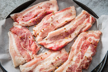 Whole pepper and raw pork belly in an oven pan	