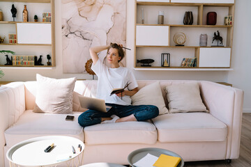 Thoughtful woman reading book in living room