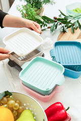 Close-up of a hand holding a plastic side dish container