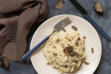Risotto with porcini mushrooms and black truffles served in a plate top view, gourmet cousine