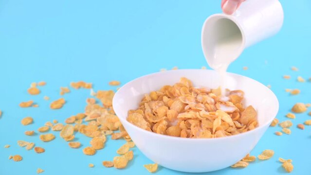 Corn flakes and milk. Sweet dry breakfast on a bright background. baby food. High quality FullHD footage