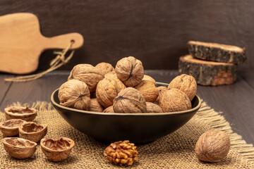 Walnuts in a bowl. Walnut shells and kernel on a burlap cloth.