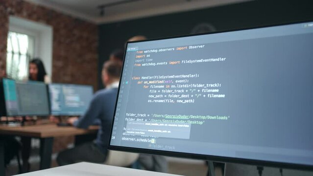 Computer Display With Program Code In Office Of IT-company, Group Of Data Scientists In Background