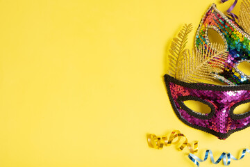 Festive face masks for masquerade or carnival celebration on colored background. Blank greeting card or invitation