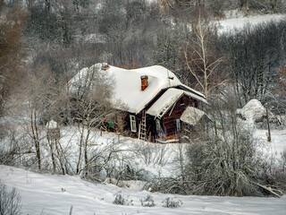Magnificent view of an old wooden house covered with snow