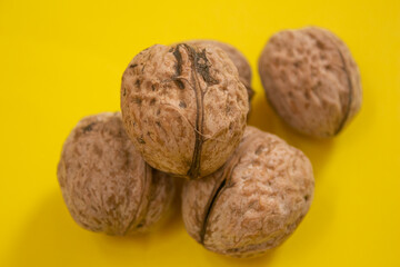 Dried walnuts on yellow background