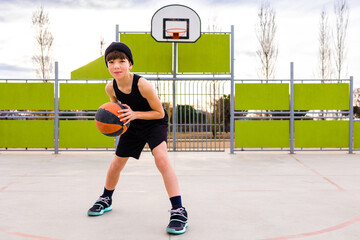 Boy with basketball on sports ground