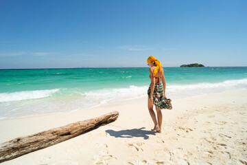 Summer vacation. Carefree joyful woman walking on white sand, relaxing and enjoying tropical beach....