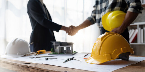 Shaking hands, Blueprints architects and building engineers talking meeting and planning will chronicle the design and technical aspects of a new house construction, renovation remodeling