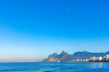 Fototapeta na wymiar Sunrise on Ipanema beach in Rio de Janeiro with the moon in the sky