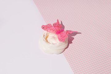Meringue nest decorated with pink  butterfly, summer dessert recipe idea. Pink, romantic, aesthetic, retro style layout. 