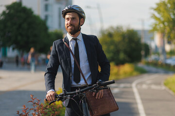 Cheerful employee in gray helmet enjoying view, while cycling outdoors.