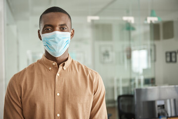 Fototapeta na wymiar African businessman standing in his office wearing a face mask