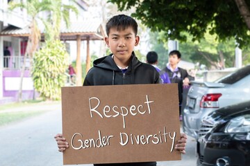 Asian boy holds brown protesting paper which has texts 