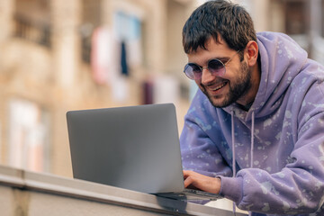 young man with laptop outdoors