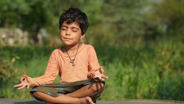 Young Indian female child practicing yoga in the park in day time.