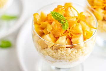 Fototapeta na wymiar Millet groats dessert with caramelised apples, natural yoghurt and orange peel. White background