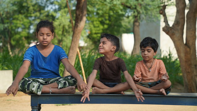 kids doing yoga pose in the park outdoor. Healthy life style concept.