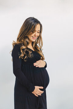 Calm pregnant woman touching baby bump