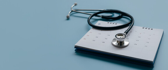 Black stethoscope,calendar on blue background, health care concept